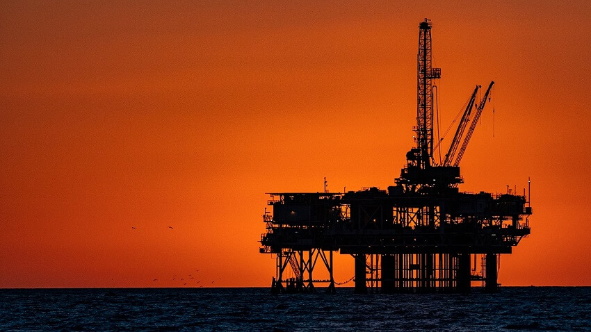 An oil rig silhouetted against a sunset