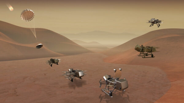 3D illustration of the Dragonfly mission with several robotic flying craft on a red hilly surface.