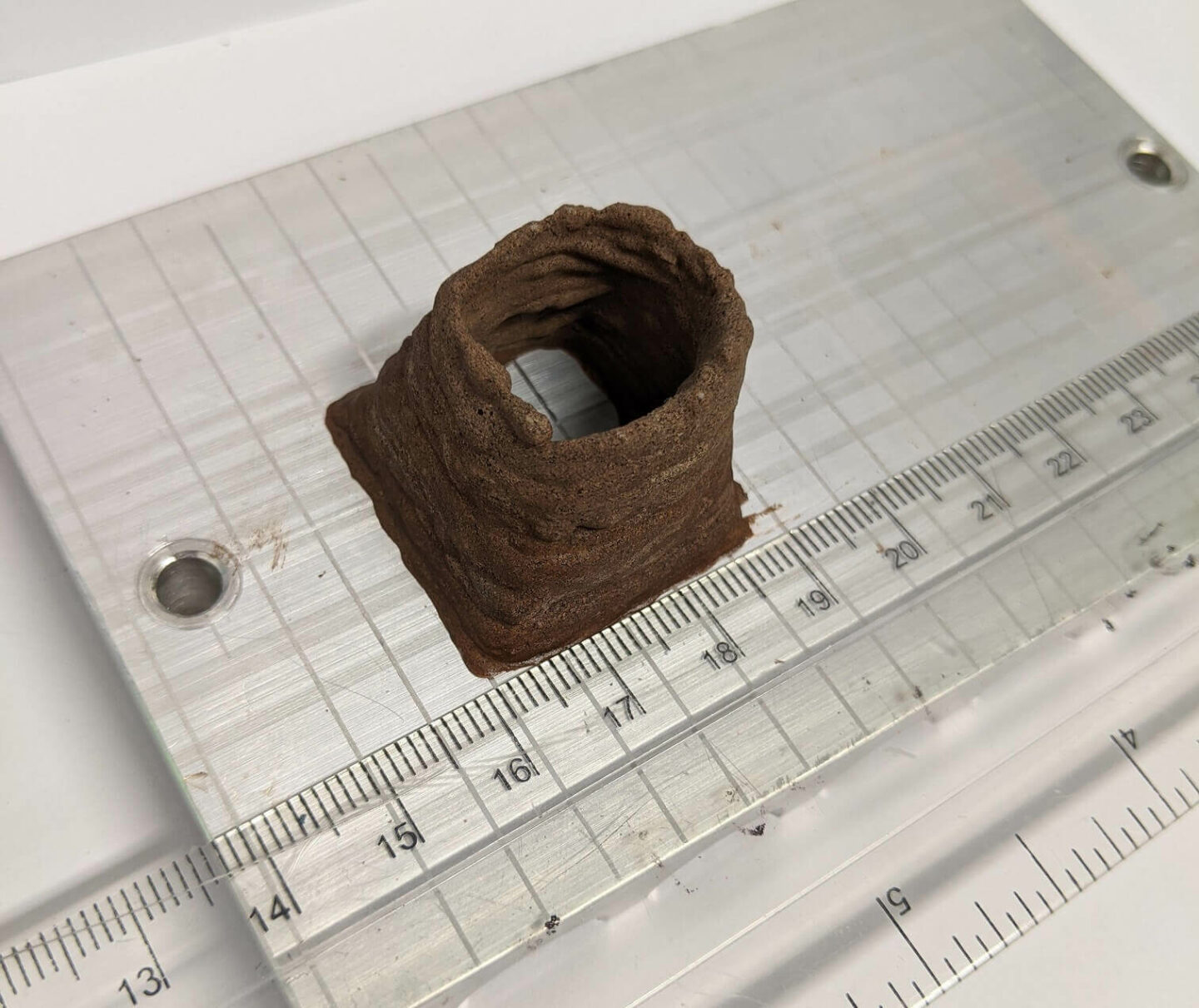 A brown, hollow mound. It is next to a rule. It is 2cm wide