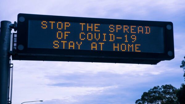 led traffic sign saying stop the spread of covid-19 stay at home