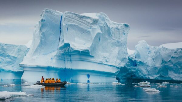 antarctic tourism a small boat of tourists floating among icebergs or an ice shelf in antarctica