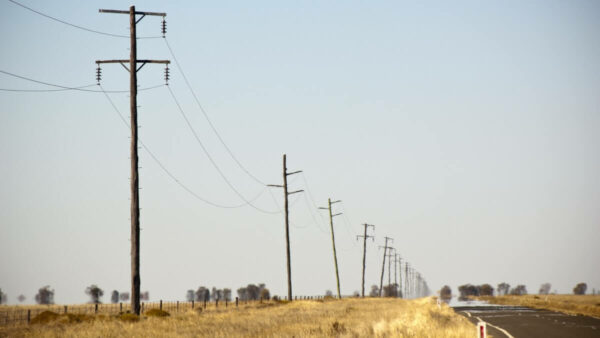 power lines along an Australian road, representing the road ahead for the Australian energy crisis
