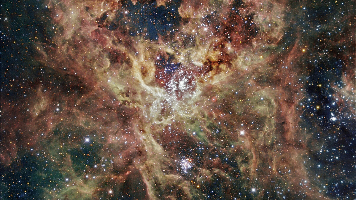 A hubble space image showing a colourful swirl of gas and many bright spots