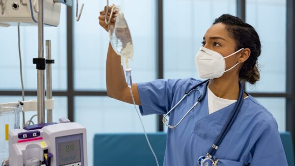 nurse-wearing-respirator-puts-iv-drip