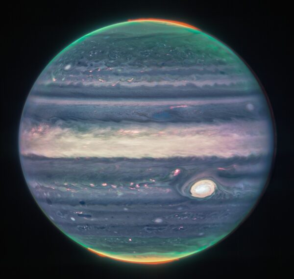 Jupiter in untraditional colours. Mostly blue and whites. There's a green and yellow smudge at the top and bottom of the planet. 