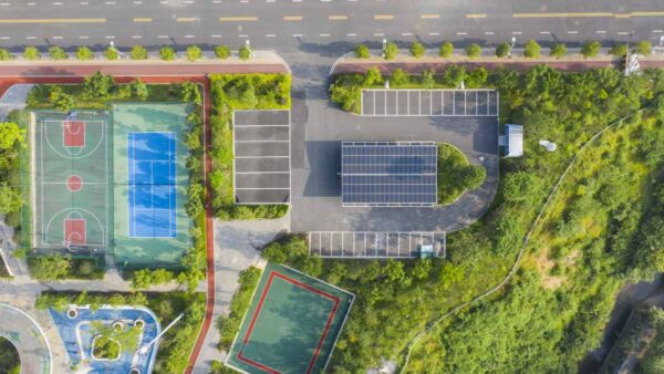 aerial view of solar panels, trees, EV chargin carpark, symbolising decarbonisation