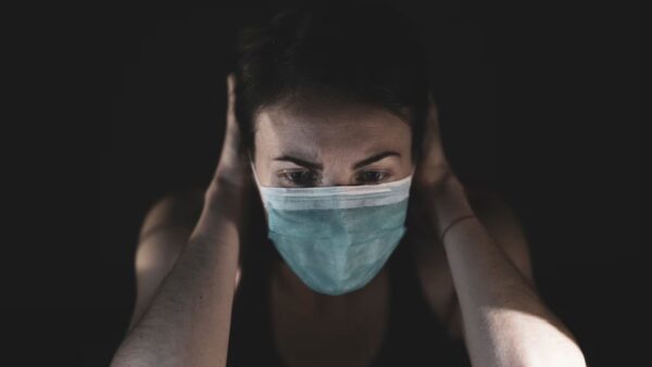 A woman puts on a surgical mask