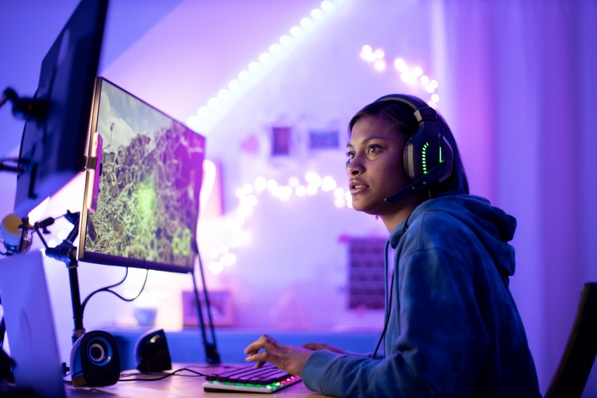 Gamer wears headphones while playing at her computer