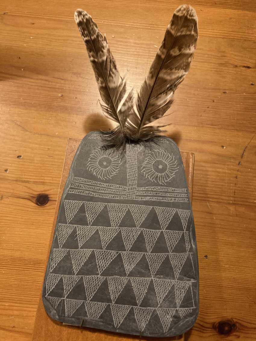 owl plaqu replica on table with two feathers in the top