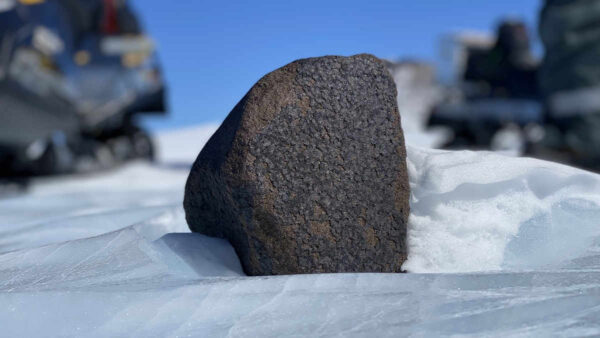 black-rock-meteorite-close-up-in-ice
