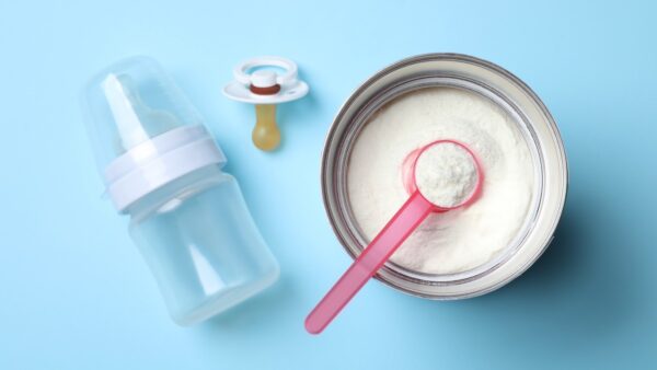 baby formula in tin with scoop, baby bottle and dummy