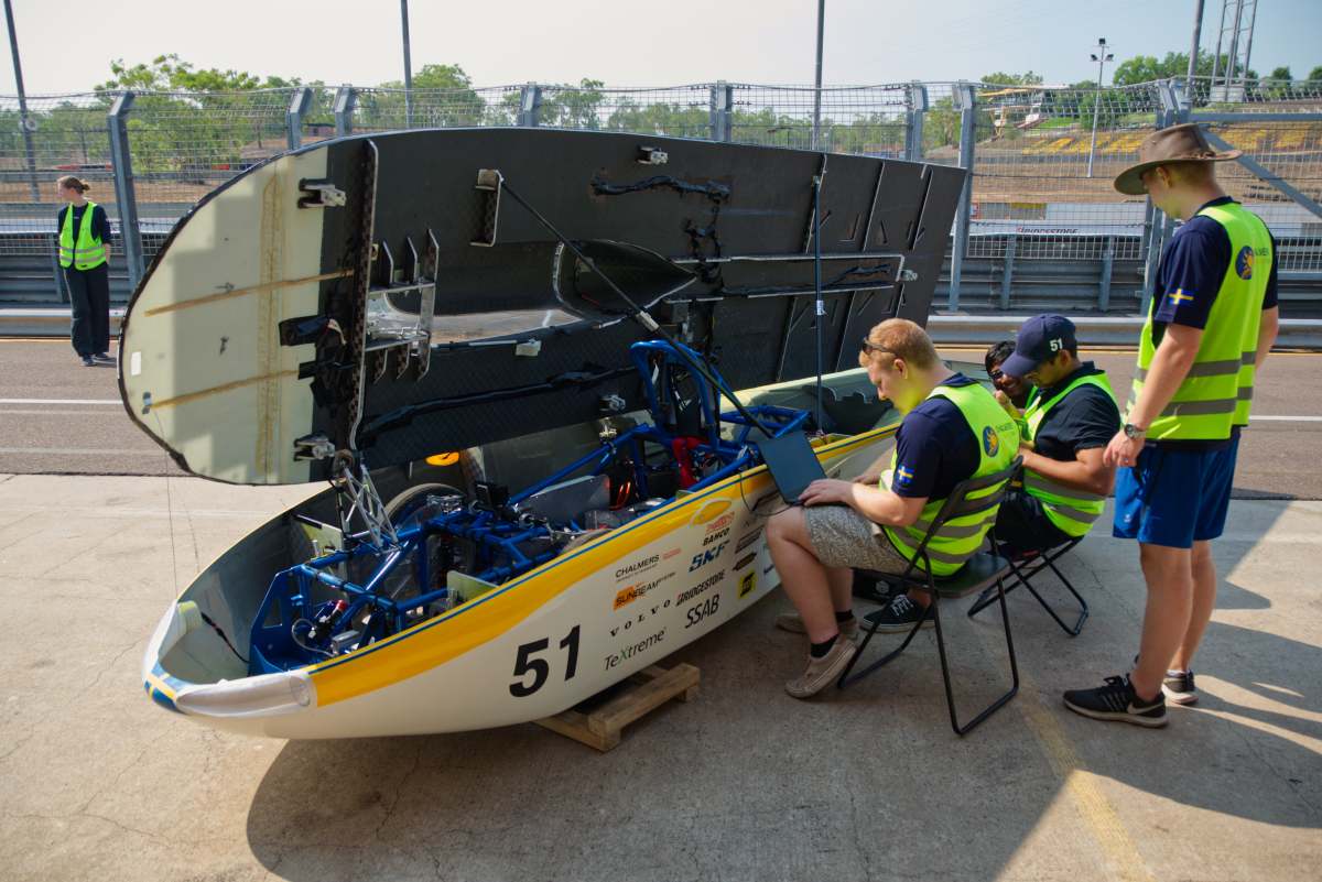 keeping cool, swedish style 5 A solar car with its canopy raised is monitored by four men.