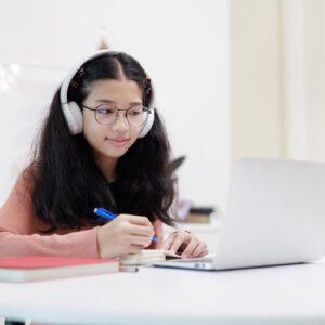 new writing program opens for teen stem enthusiasts 1 A teen asian girl is captured studying online at home, using a laptop and headphones.